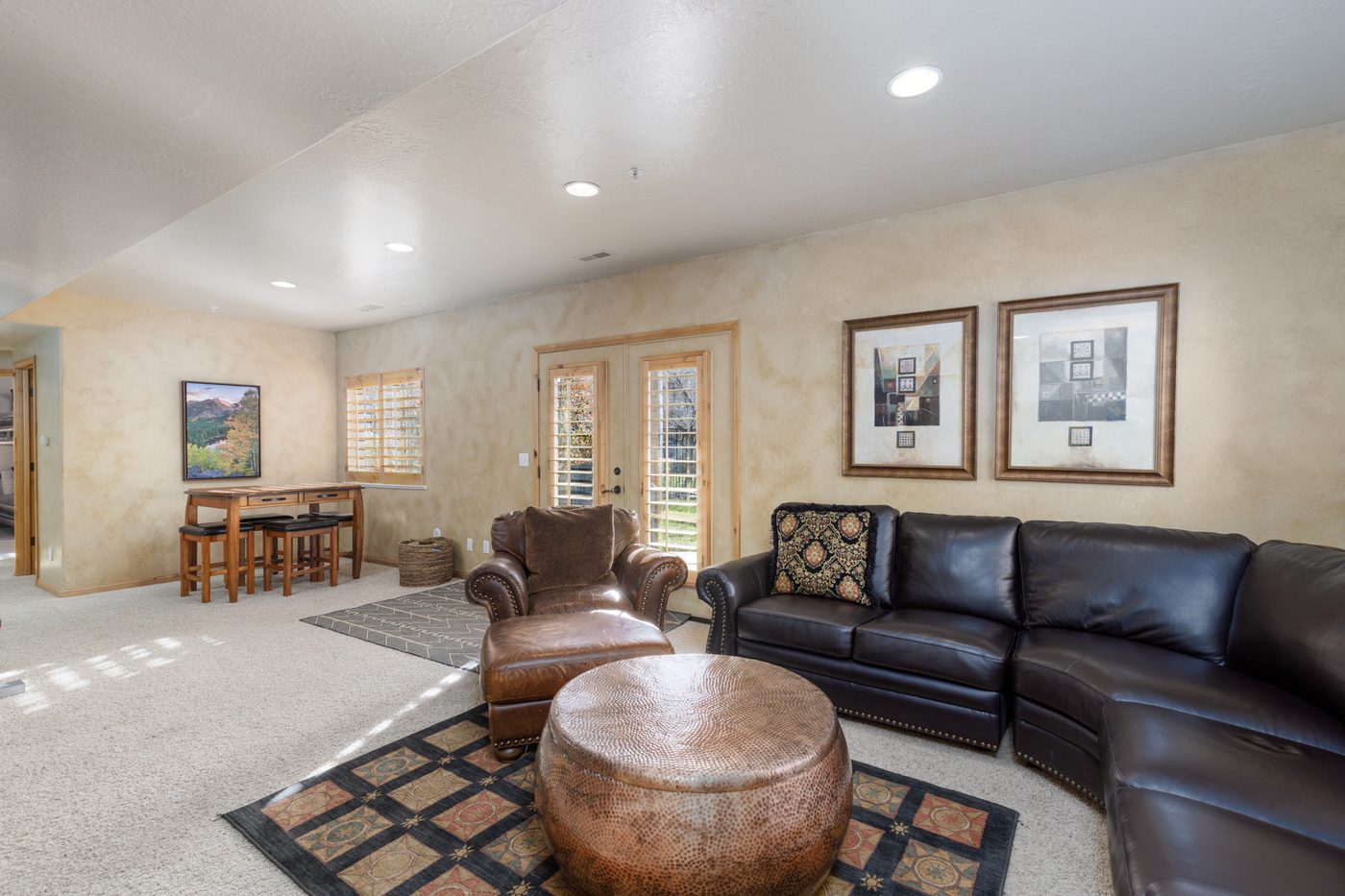 Lower-level family room with a leather sectional and games table