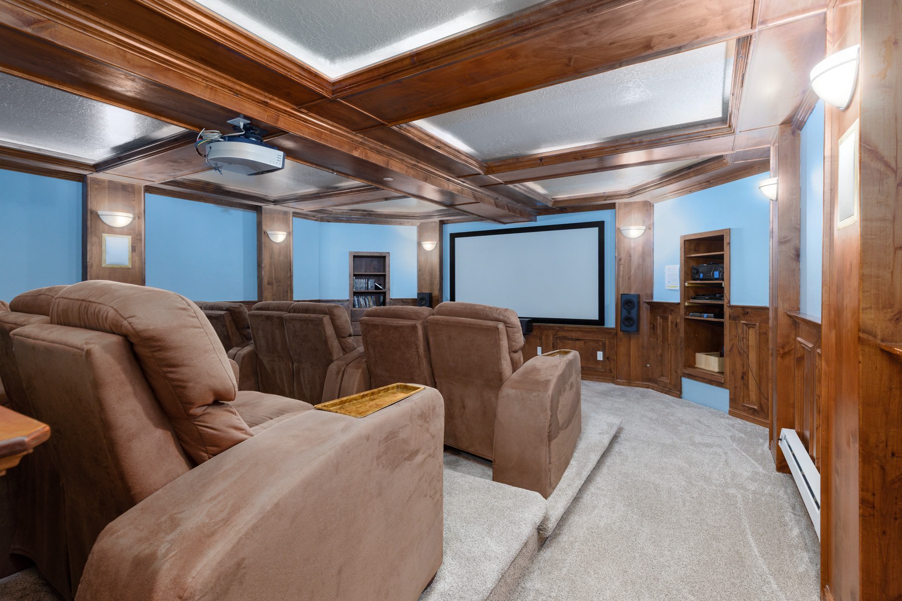The home theater at Cascades 102, twelve tiered reclining seats, projection screen and a coffered alder ceiling