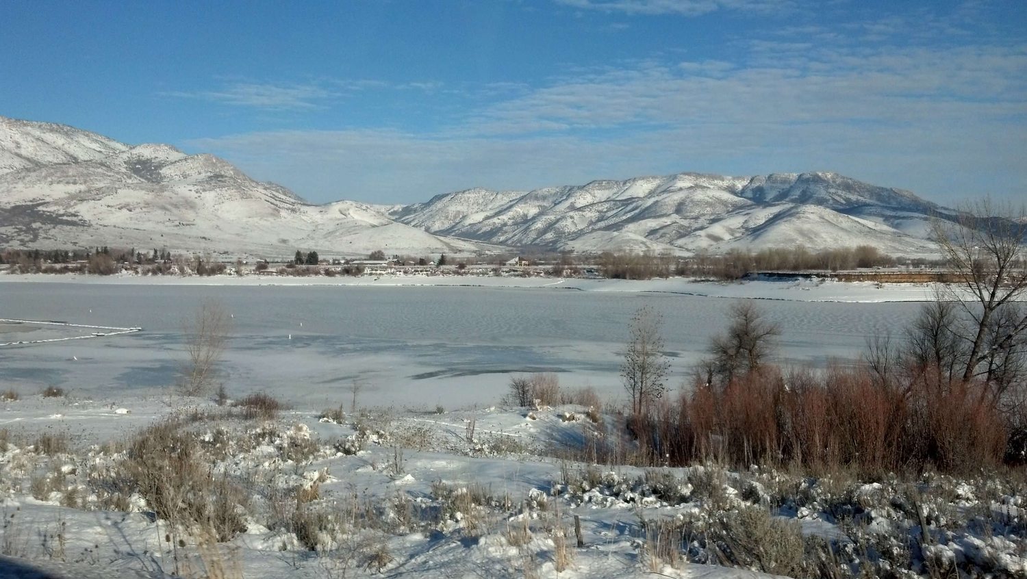 Pineview Reservoir frozen over in midwinter below the snow-covered range